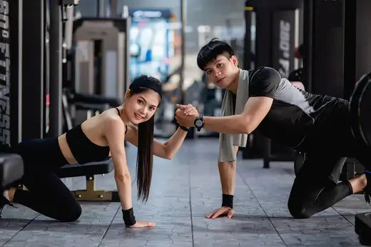 Two individuals exercising with gym equipment, demonstrating effective workout techniques using kettlebells and dumbbells.