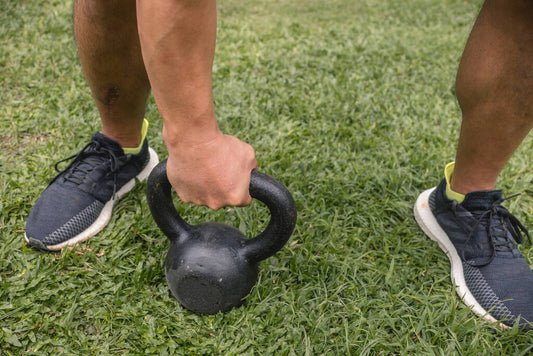 male picks kettlebell garden